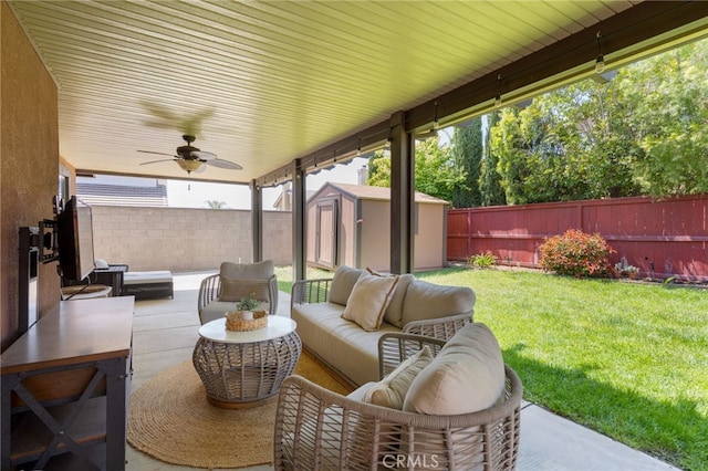 view of patio / terrace featuring a storage shed, ceiling fan, a fenced backyard, and an outdoor hangout area