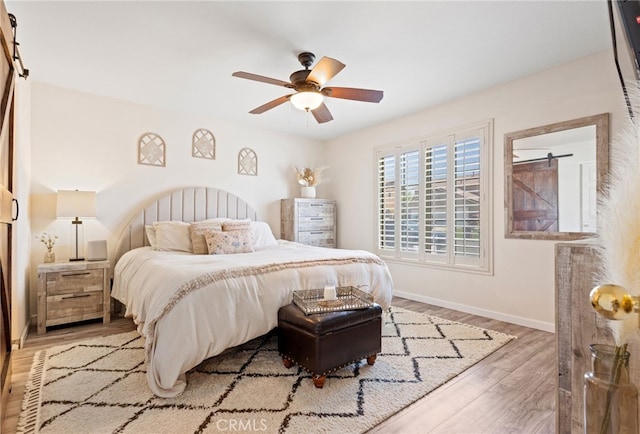 bedroom with a ceiling fan, baseboards, and wood finished floors