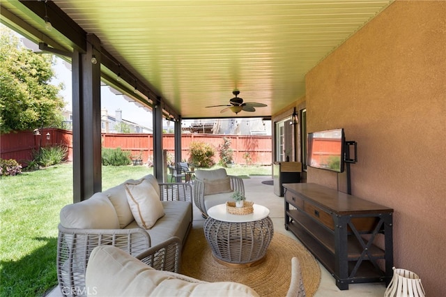 view of patio featuring ceiling fan, an outdoor living space, and a fenced backyard