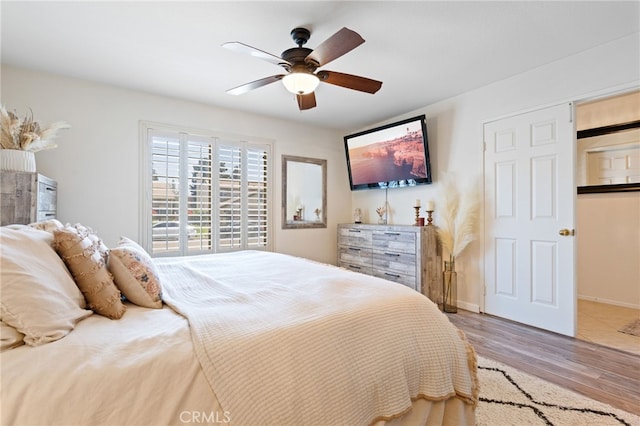 bedroom with baseboards, ceiling fan, and wood finished floors