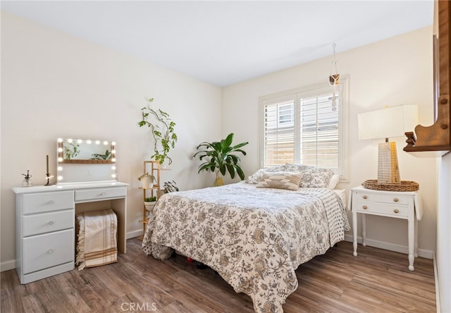 bedroom featuring baseboards and wood finished floors