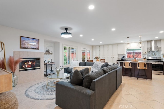 living area with light tile patterned floors, a tiled fireplace, and recessed lighting