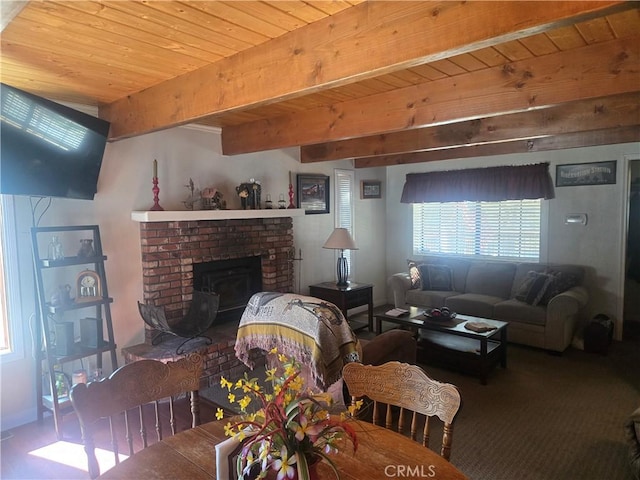 living area featuring beamed ceiling, wooden ceiling, and a fireplace