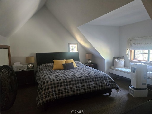 bedroom featuring carpet, vaulted ceiling, and multiple windows