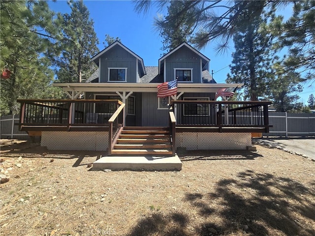 view of front facade featuring fence and a wooden deck