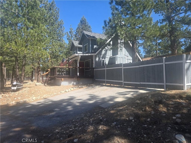 view of property exterior with a wooden deck and fence