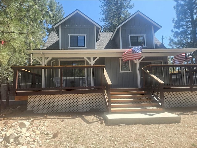 back of house featuring a porch, a shingled roof, and board and batten siding