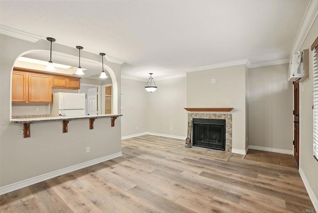 4230 48th St Unit 5, San Diego, CA 92115 - unfurnished living room with light wood-style floors, a fireplace, baseboards, a wall unit AC, and crown molding