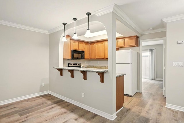 4230 48th St Unit 5, San Diego, CA 92115 - kitchen featuring light wood-style floors, a kitchen breakfast bar, black microwave, light stone counters, and freestanding refrigerator