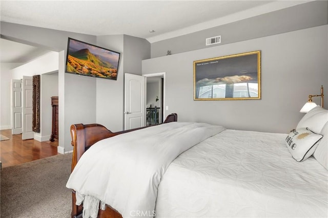 bedroom with baseboards, visible vents, carpet floors, and lofted ceiling