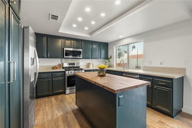 kitchen with recessed lighting, butcher block countertops, appliances with stainless steel finishes, light wood-type flooring, and visible vents
