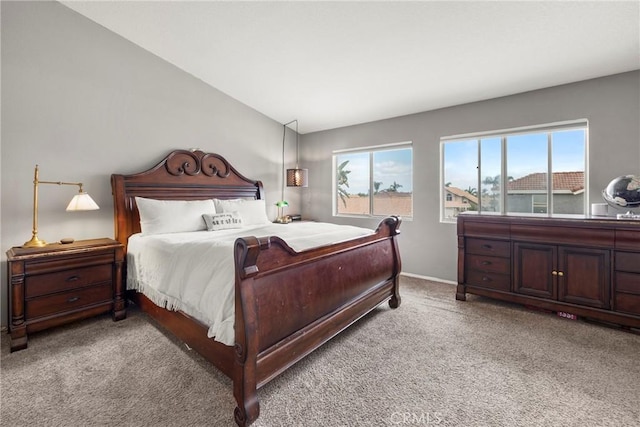 carpeted bedroom with lofted ceiling, baseboards, and multiple windows