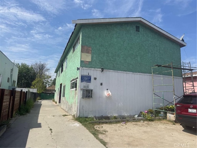 view of property exterior with fence and stucco siding