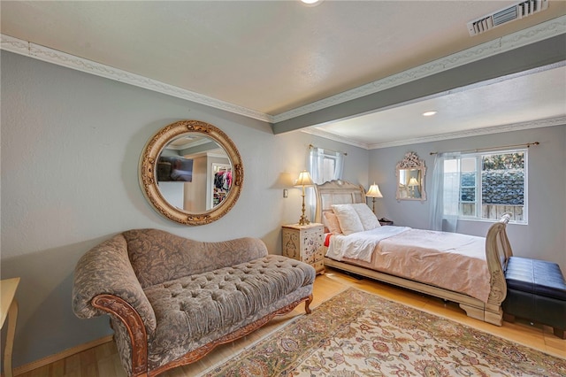 bedroom featuring recessed lighting, beam ceiling, visible vents, ornamental molding, and wood finished floors