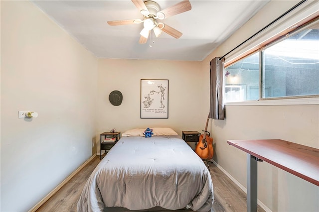 bedroom featuring wood finished floors, a ceiling fan, and baseboards