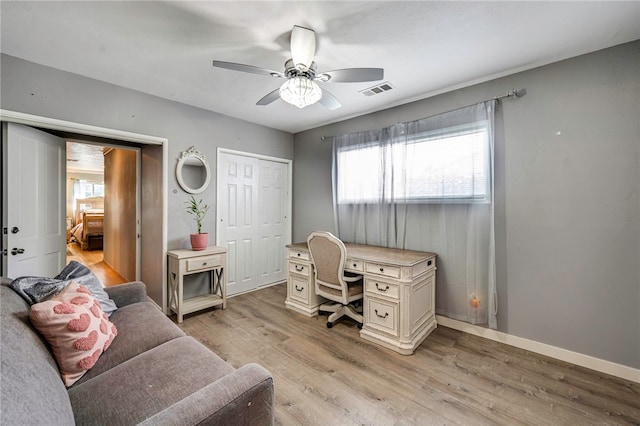 office space with visible vents, light wood-type flooring, a wealth of natural light, and ceiling fan