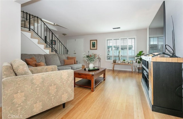 1337 Oakheath Dr, Harbor City, CA 90710 - living area featuring visible vents, stairway, light wood-style flooring, and baseboards