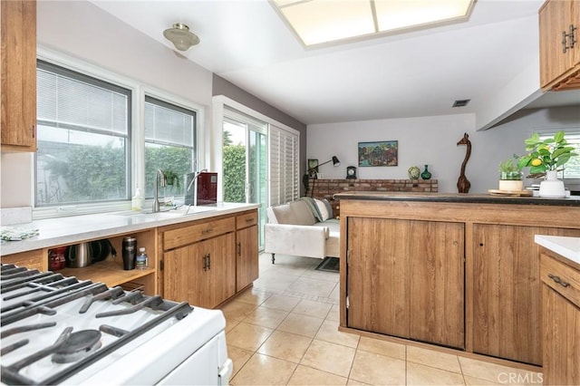 1337 Oakheath Dr, Harbor City, CA 90710 - kitchen featuring white gas range oven, brown cabinets, a sink, visible vents, and light tile patterned flooring