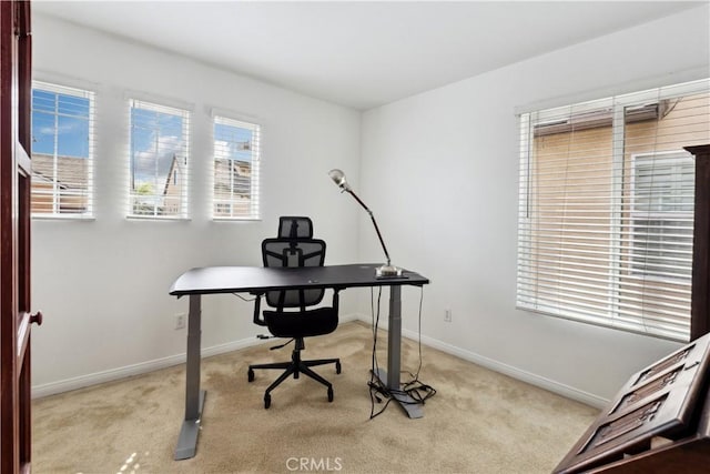 carpeted home office featuring baseboards