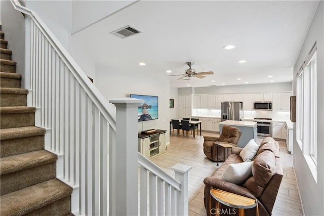 living room with visible vents, stairway, recessed lighting, a ceiling fan, and light wood-style flooring