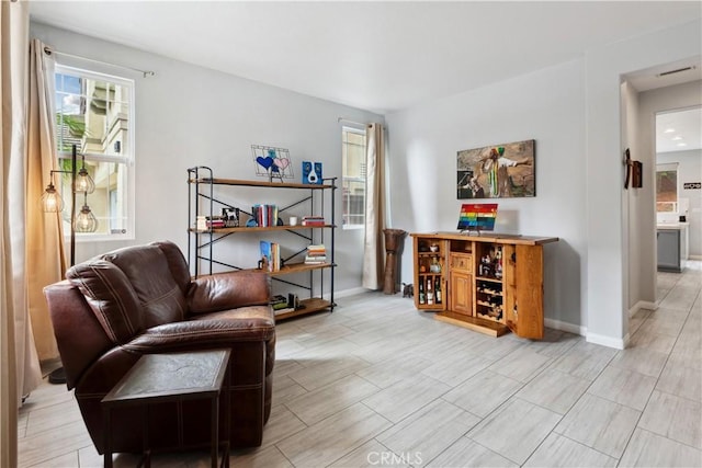living area with baseboards, plenty of natural light, and visible vents