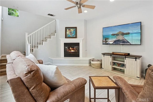 living room with a ceiling fan, visible vents, stairs, baseboards, and recessed lighting