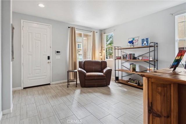 foyer entrance with baseboards and recessed lighting