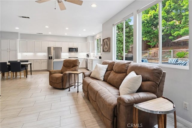 living area with recessed lighting, ceiling fan, visible vents, and baseboards