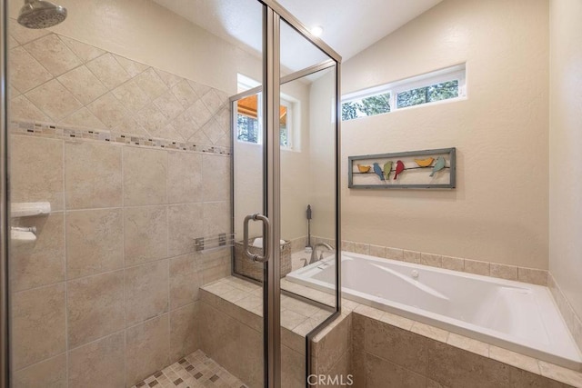 bathroom featuring a stall shower, lofted ceiling, and a bath