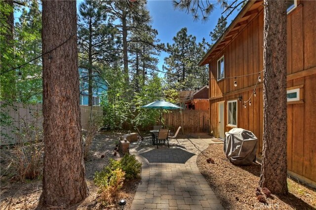 view of yard with a patio, outdoor dining area, and a fenced backyard