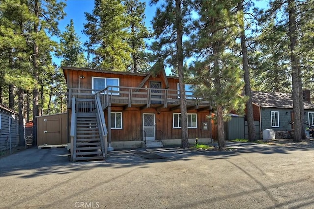 chalet / cabin featuring a storage unit, an outdoor structure, entry steps, and stairs