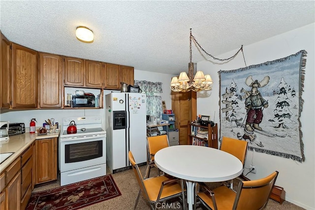 kitchen with light countertops, a chandelier, brown cabinetry, and white appliances