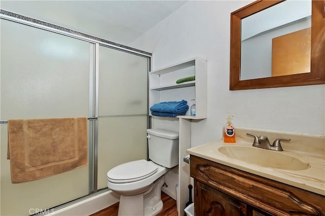 bathroom with wood finished floors, vanity, toilet, and a shower stall