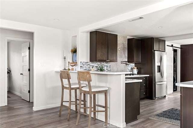 5222 Foster Rd, Paradise, CA 95969 - kitchen with decorative backsplash, dark brown cabinetry, wood finished floors, light countertops, and stainless steel fridge