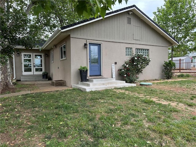 5222 Foster Rd, Paradise, CA 95969 - rear view of house featuring a lawn, stucco siding, and french doors