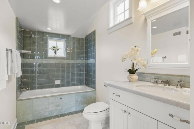 bathroom featuring tiled shower / bath combo, tile patterned floors, toilet, vanity, and visible vents
