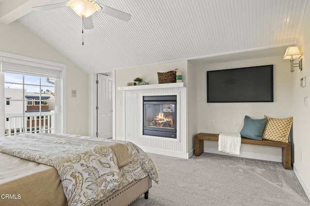 bedroom with lofted ceiling with beams, access to exterior, carpet flooring, a glass covered fireplace, and baseboards
