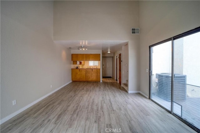 10710 El Camino Real Unit 26, Atascadero, CA 93422 - unfurnished living room with visible vents, light wood finished floors, and baseboards