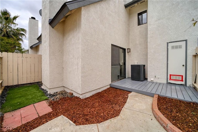 10710 El Camino Real Unit 26, Atascadero, CA 93422 - view of exterior entry featuring fence, cooling unit, and stucco siding