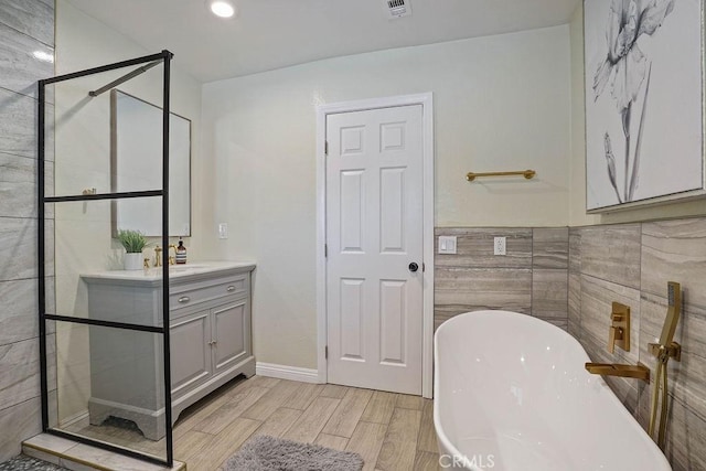 2161 Stonefield Pl, Riverside, CA 92506 - full bath with tile walls, a stall shower, wood finished floors, vanity, and a soaking tub