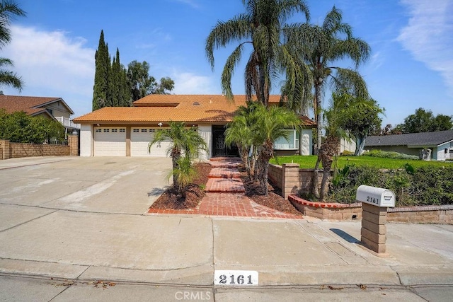 2161 Stonefield Pl, Riverside, CA 92506 - ranch-style house featuring an attached garage, driveway, a tile roof, and stucco siding