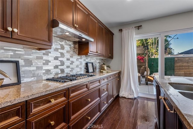 54 Revell Cir, Buena Park, CA 90620 - kitchen featuring under cabinet range hood, stainless steel gas stovetop, dark wood-type flooring, backsplash, and light stone counters