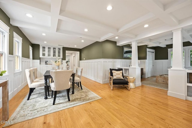 dining space featuring coffered ceiling, wainscoting, and decorative columns