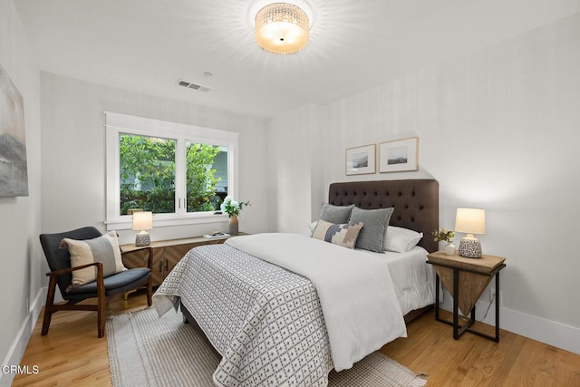 bedroom with light wood-style floors, baseboards, and visible vents