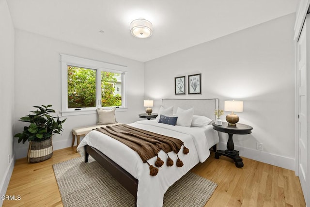 bedroom featuring light wood-style floors and baseboards