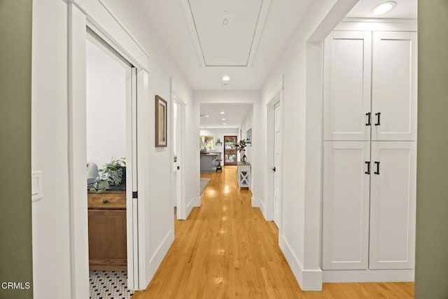hallway featuring recessed lighting, baseboards, attic access, and light wood finished floors