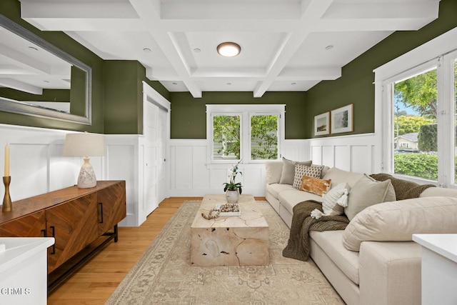 living area featuring wainscoting, beam ceiling, a decorative wall, light wood-style floors, and coffered ceiling