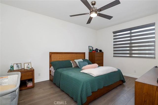 bedroom with baseboards, wood finished floors, and a ceiling fan