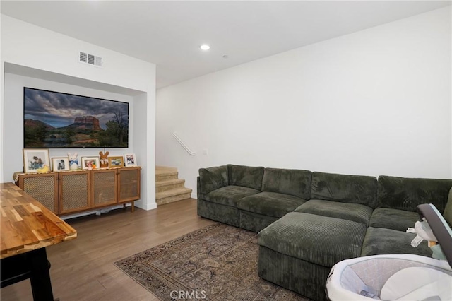 living room featuring recessed lighting, wood finished floors, stairs, baseboards, and visible vents