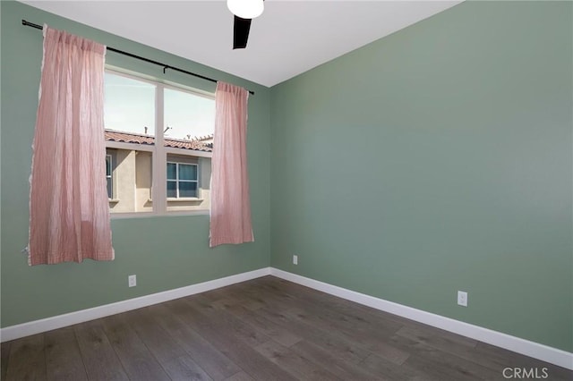 empty room with dark wood-style floors and baseboards